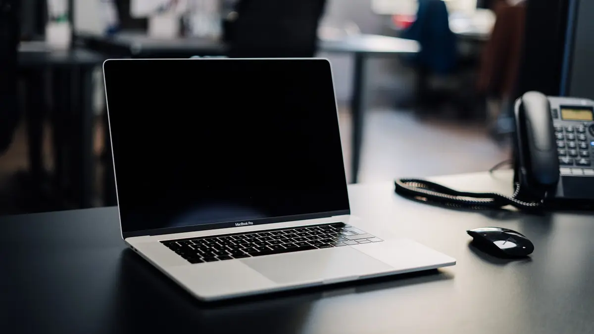 Aufgeklappter Laptop auf einem Schreibtisch im Büro – bereit für den nächsten Prompt